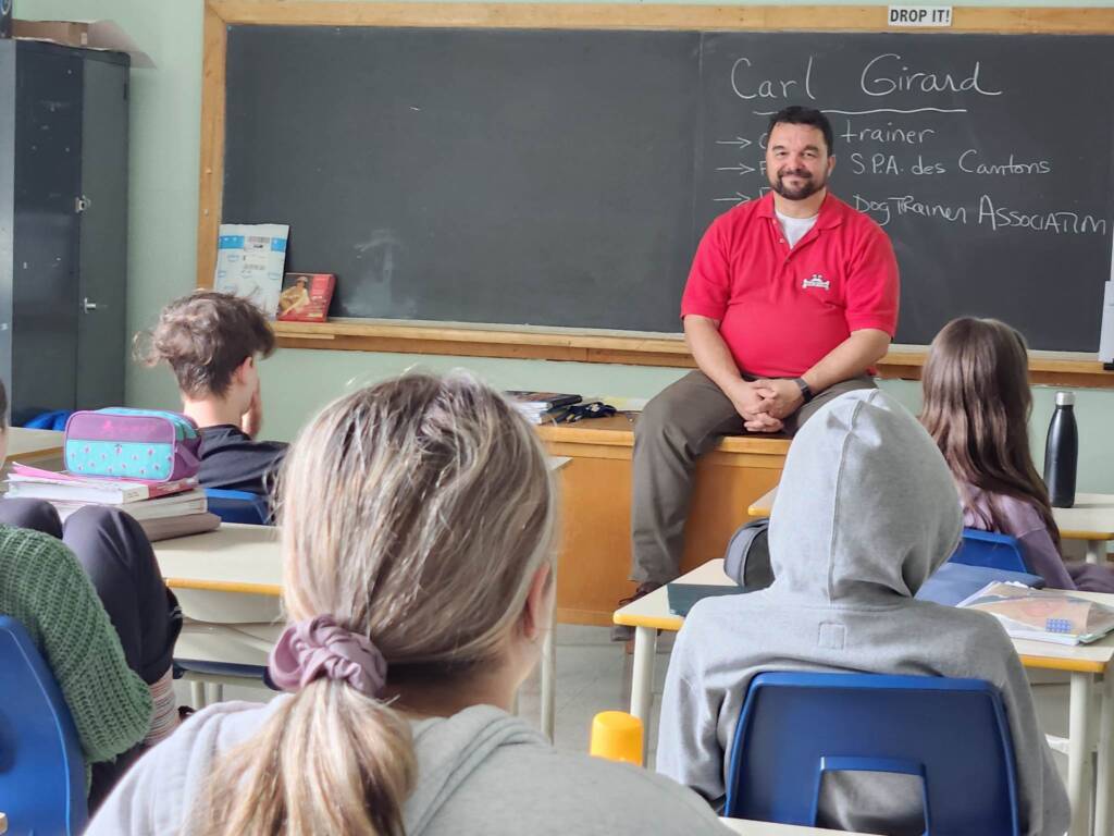 Éducateur canin conférencier en classe dans une école secondaire avec des ados